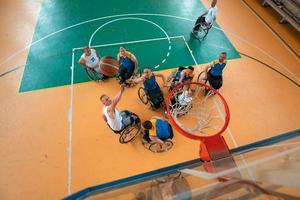 Inaktiverad krig eller arbete veteraner blandad lopp och ålder basketboll lag i rullstolar spelar en Träning match i en sporter Gym hall. handikappade människor rehabilitering och inkludering begrepp. foto