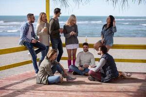 grupp av vänner har roligt på höst dag på strand foto