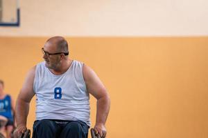 en Foto av en krig veteran- spelar basketboll med en team i en modern sporter arena. de begrepp av sport för människor med funktionshinder