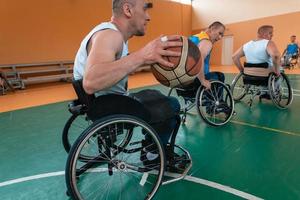 Inaktiverad krig veteraner blandad lopp och ålder basketboll lag i rullstolar spelar en Träning match i en sporter Gym hall. handikappade människor rehabilitering och inkludering begrepp foto