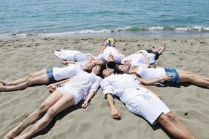 grupp av Lycklig ung människor i ha roligt på strand foto