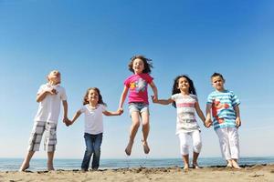 Lycklig ung människor grupp ha roligt på strand foto