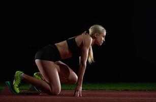 kvinna sprinter lämnar startande block foto