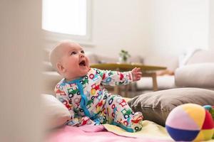 nyfödd bebis pojke Sammanträde på färgrik filtar foto