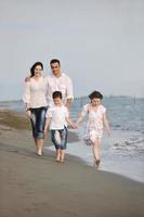 Lycklig ung familj ha roligt på strand foto