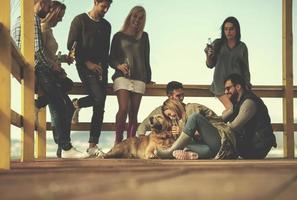 grupp av vänner har roligt på höst dag på strand foto