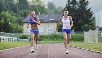 två flickor löpning på atletisk lopp Spår foto