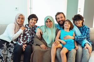 porträtt Foto av ett arab muslim familj Sammanträde på en soffa i de levande rum av en stor modern hus. selektiv fokus