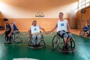 Inaktiverad krig veteraner blandad lopp och ålder basketboll lag i rullstolar spelar en Träning match i en sporter Gym hall. handikappade människor rehabilitering och inkludering begrepp foto