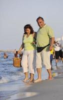 Lycklig seniors par på strand foto