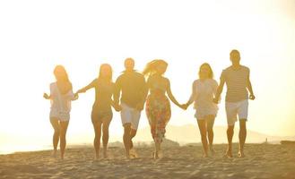 Lycklig ung människor grupp ha roligt på strand foto