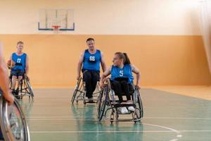 Inaktiverad krig veteraner blandad lopp motsatt basketboll lag i rullstolar fotograferad i verkan medan spelar ett Viktig match i en modern hall. foto