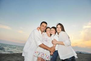 Lycklig ung familj ha roligt på strand foto