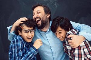Lycklig far kramas söner oförglömlig stunder av familj glädje i blandad lopp mitten östra arab familj foto