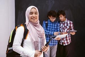 arabicum tonåringar team, studenter grupp arbetssätt tillsammans på bärbar dator och läsplatta dator uppkopplad klassrum utbildning begrepp foto