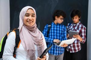 arabicum tonåringar team, studenter grupp arbetssätt tillsammans på bärbar dator och läsplatta dator uppkopplad klassrum utbildning begrepp foto