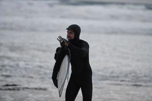 arktisk surfare gående förbi strand efter surfing foto