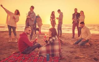 par njuter med vänner på solnedgång på de strand foto