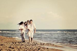 Lycklig ung familj ha roligt på strand foto