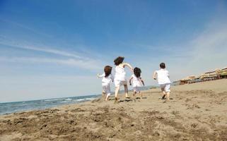 glad barn grupp som leker på stranden foto