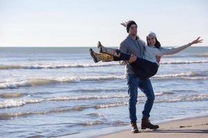 kärleksfull ung par på en strand på höst solig dag foto