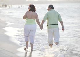 Lycklig seniors par på strand foto