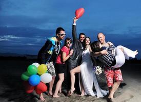 Lycklig ung människor grupp ha roligt på strand foto