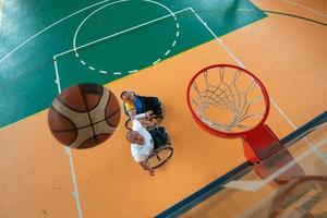 Inaktiverad krig eller arbete veteraner blandad lopp och ålder basketboll lag i rullstolar spelar en Träning match i en sporter Gym hall. handikappade människor rehabilitering och inkludering begrepp. foto