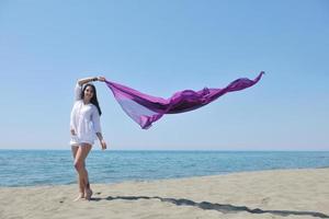 skön ung kvinna på strand med scarf foto