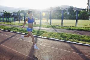 kvinna joggning på tidigt morgon- foto