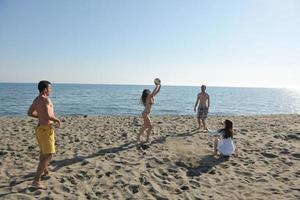 ung människor grupp ha roligt och spela strand volleyboll foto