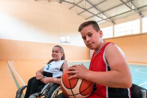 de pojke sitter i en rullstol och förbereder för de basketboll Start av de spel i de stor arena. selektiv fokus foto