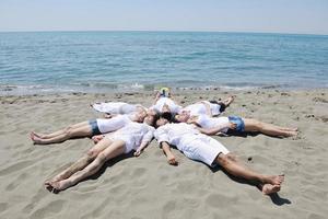 grupp av Lycklig ung människor i ha roligt på strand foto