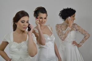 porträtt av en tre skön kvinna i bröllop klänning foto