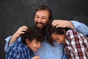 Lycklig far kramas söner oförglömlig stunder av familj glädje i blandad lopp mitten östra arab familj foto