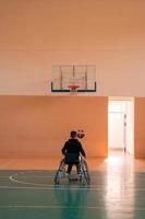 en Foto av en krig veteran- spelar basketboll i en modern sporter arena. de begrepp av sport för människor med funktionshinder