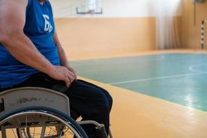 en handikappade basketboll spelare förbereder för en match medan Sammanträde i en rullstol.förberedelser för en professionell basketboll match. de begrepp av handikapp sport foto