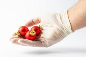 en hand i en skyddande handske symboliserar högtider i karantän. distans mellan människor. foto