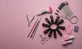 uppsättning av manikyr verktyg och Tillbehör på en rosa bakgrund. hårdvara manikyr, platt lägga. foto