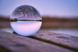 glas boll på en trä- pir på en svenska sjö på kväll timme. natur skandinavien foto