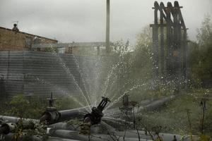 rör ventil fel. strömma av kokande vatten. stål rör pank. nödsituation. rörledning olycka. foto