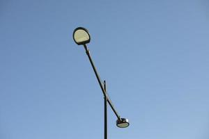 Pol med lampa mot himmel. belysning fixtur i stad. foto