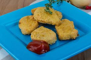 nuggets på de tallrik och trä- bakgrund foto