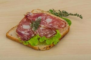 salami smörgås på trä- bakgrund foto