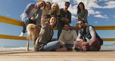 grupp av vänner har roligt på höst dag på strand foto