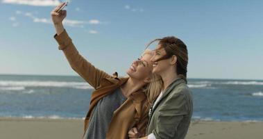flickor har tid och tar selfie på en strand foto