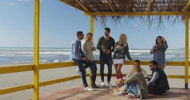 grupp av vänner har roligt på höst dag på strand foto