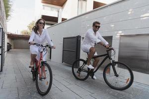 senior par njuter en skön morgon- tillsammans ridning en cykel. selektiv fokus foto