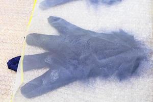 våt handske med ny fibrer under plast maska foto