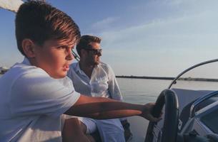 far och son njut av deras semester tillsammans medan ridning en lyx båt på hav. selektiv fokus foto